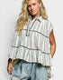 Woman wearing a striped shirt with ruffled layers on a plain background
