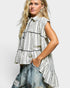 Woman wearing a striped sleeveless top with a plain background