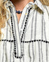 Close-up of a person wearing a white and black striped shirt with a necklace.