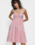 Woman wearing a pink dress with white stripes on a white background