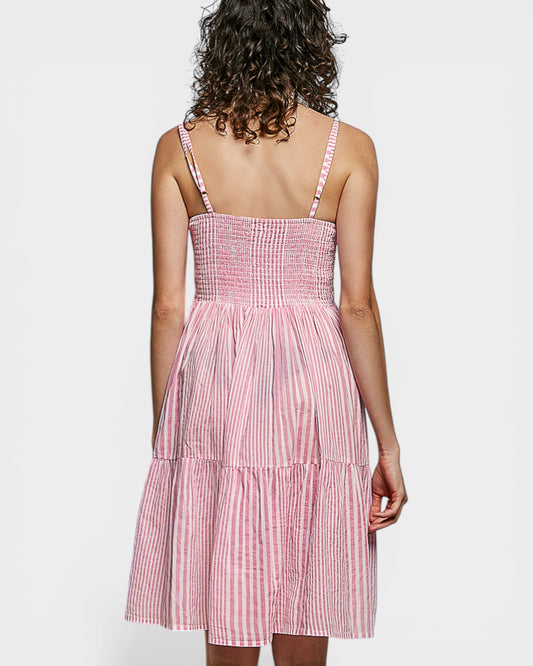 Woman wearing a pink and white checkered dress on a white background