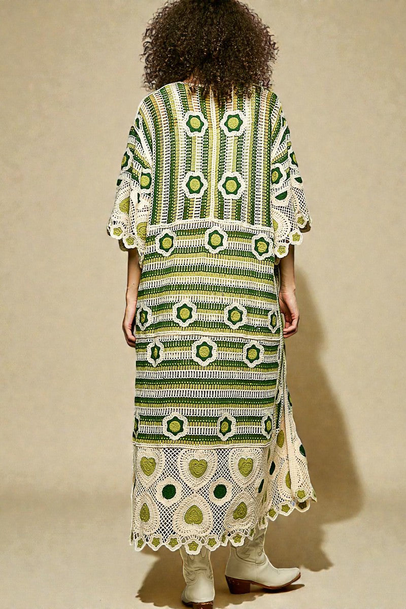 Person wearing a green and white patterned dress against a beige background
