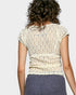 Person wearing a lace top with a plain background
