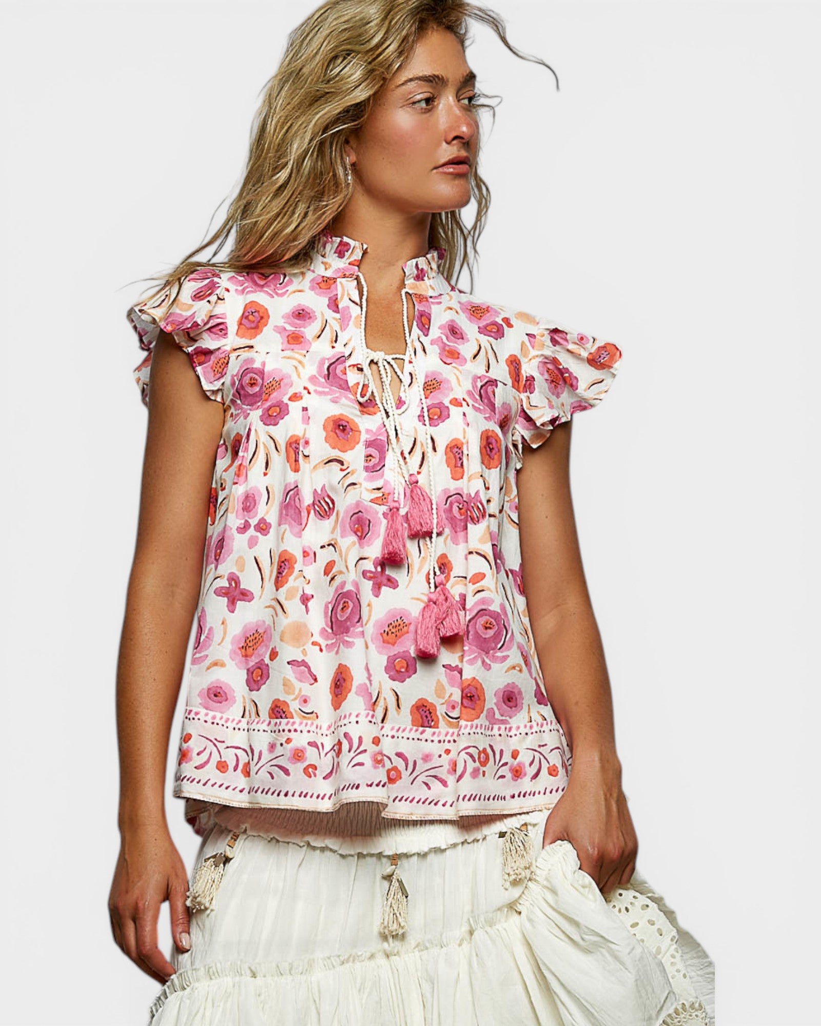 Woman wearing a floral blouse with ruffled sleeves on a white background