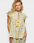 Woman wearing a floral dress with yellow and green pattern on a white background