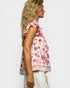 Woman wearing a floral sleeveless top on a white background