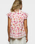Woman wearing a floral blouse with a plain background
