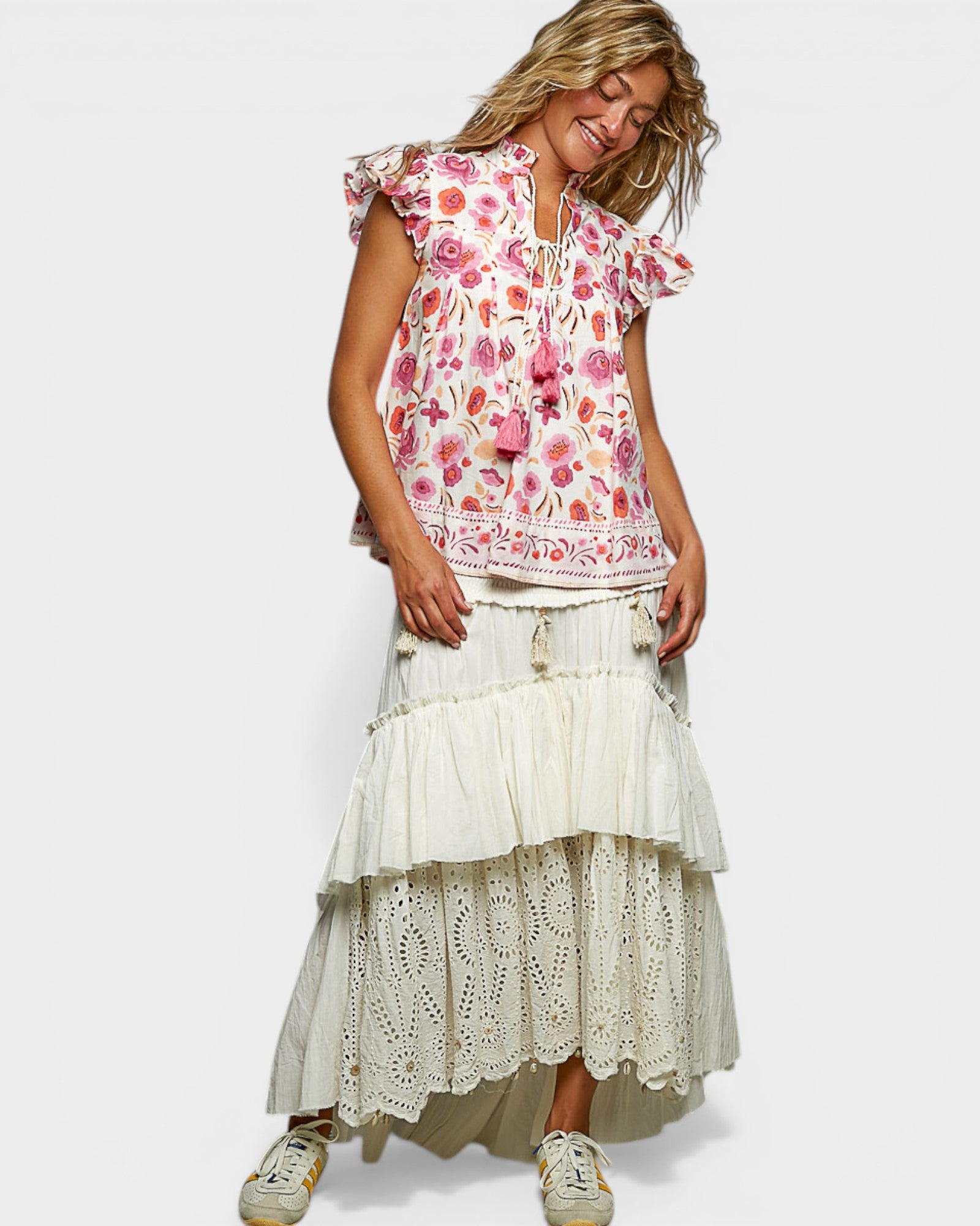 Woman wearing a floral top and layered skirt on a white background