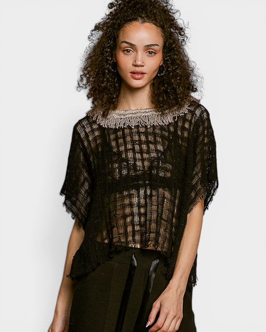 Woman wearing a black mesh top with a white background