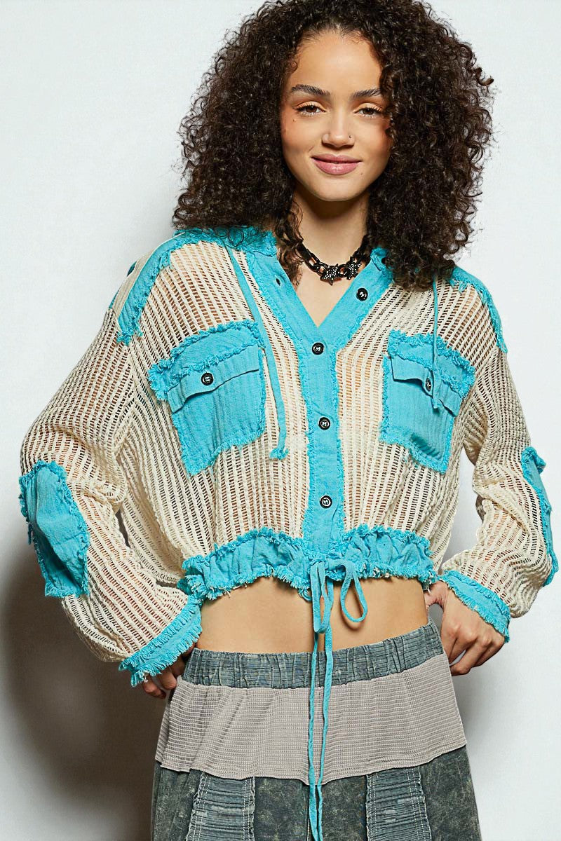 Person wearing a beige and blue cardigan with a white background