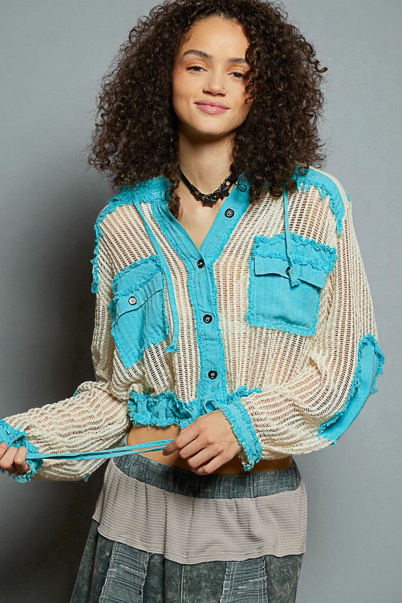 Woman wearing a beige and blue jacket with a gray background