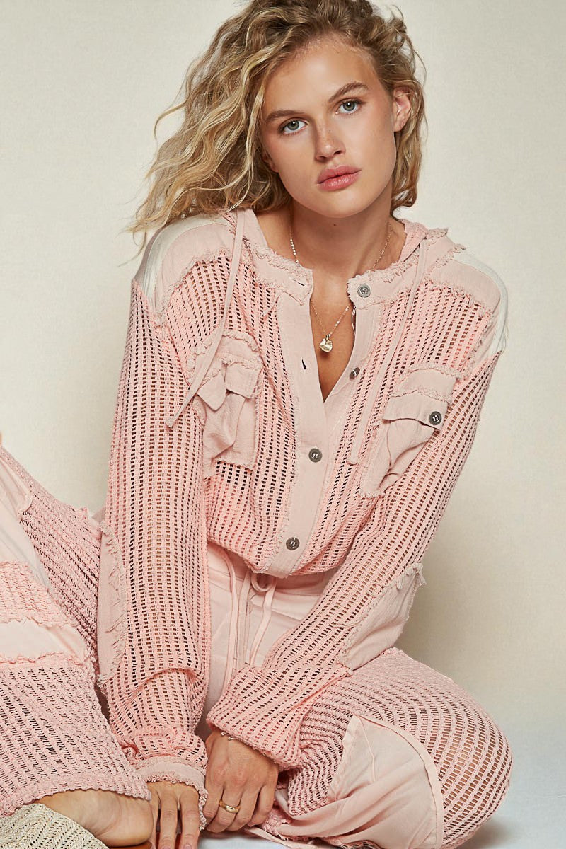 Woman wearing a pink knitted outfit sitting on a white background