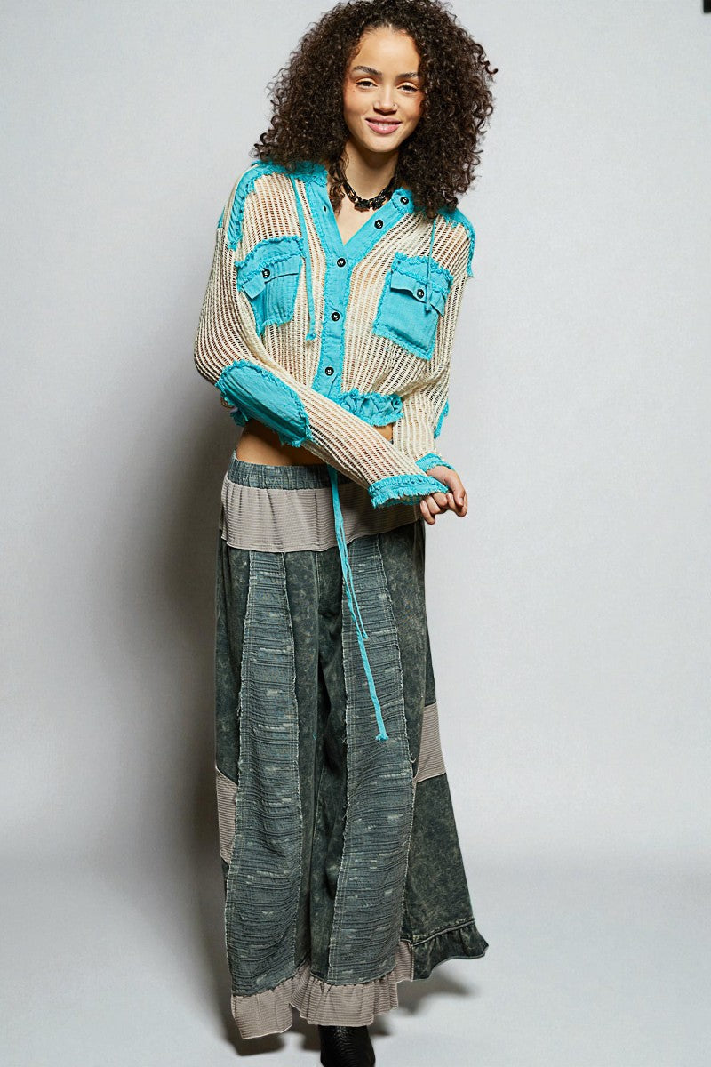 Woman wearing a long, patterned dress with a matching cardigan on a plain background