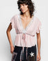 Woman wearing a pink blouse with lace details on a white background