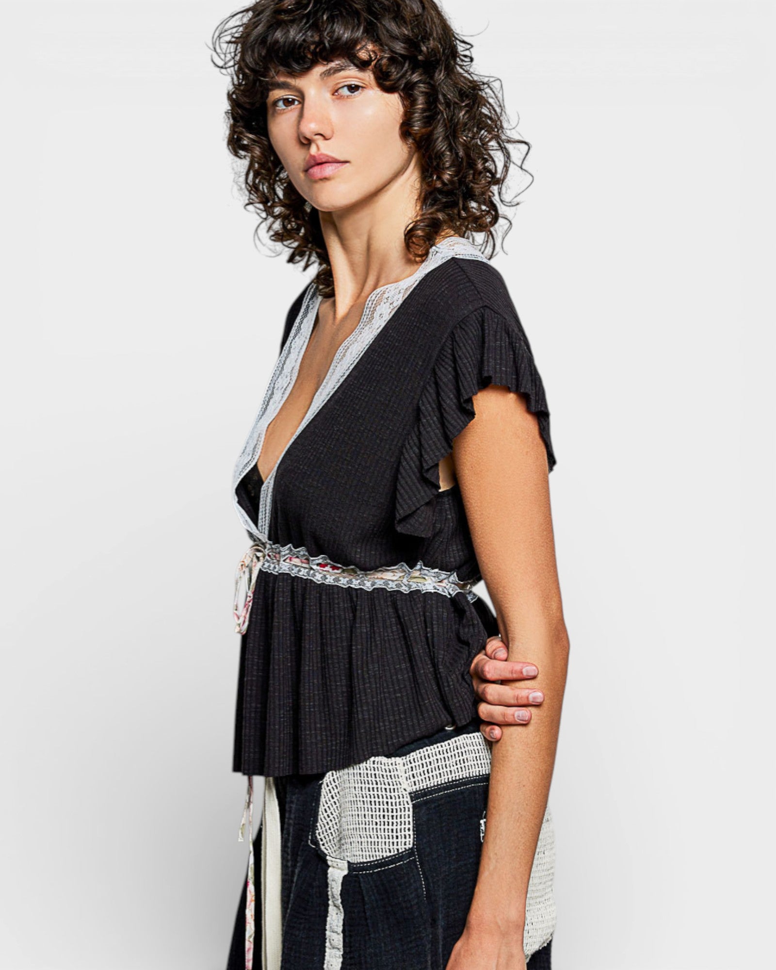 Woman wearing a black and white patterned top with a plain background