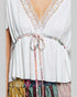 White lace-trimmed top with colorful tie and patterned bottom on a plain background
