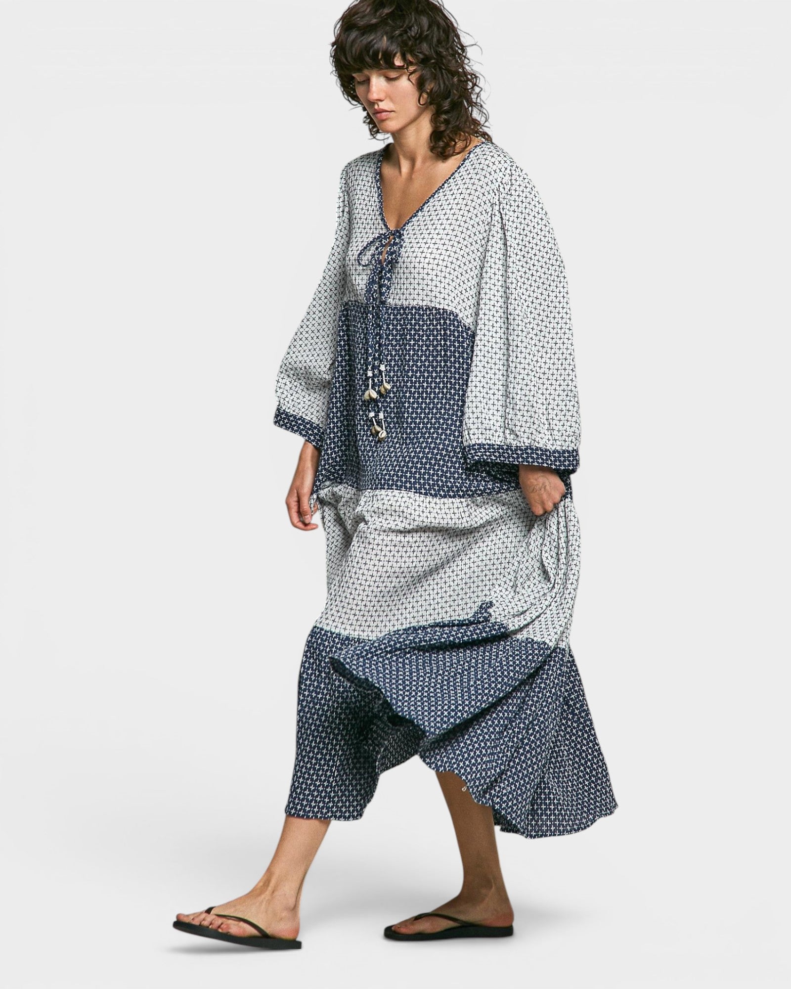 Woman wearing a blue and white patterned outfit on a white background