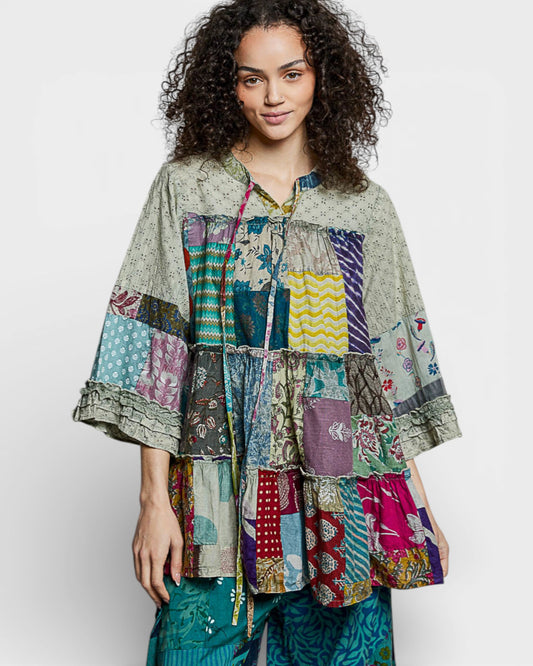 Woman wearing a colorful patchwork jacket on a white background