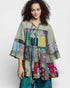 Woman wearing a colorful patchwork jacket on a white background