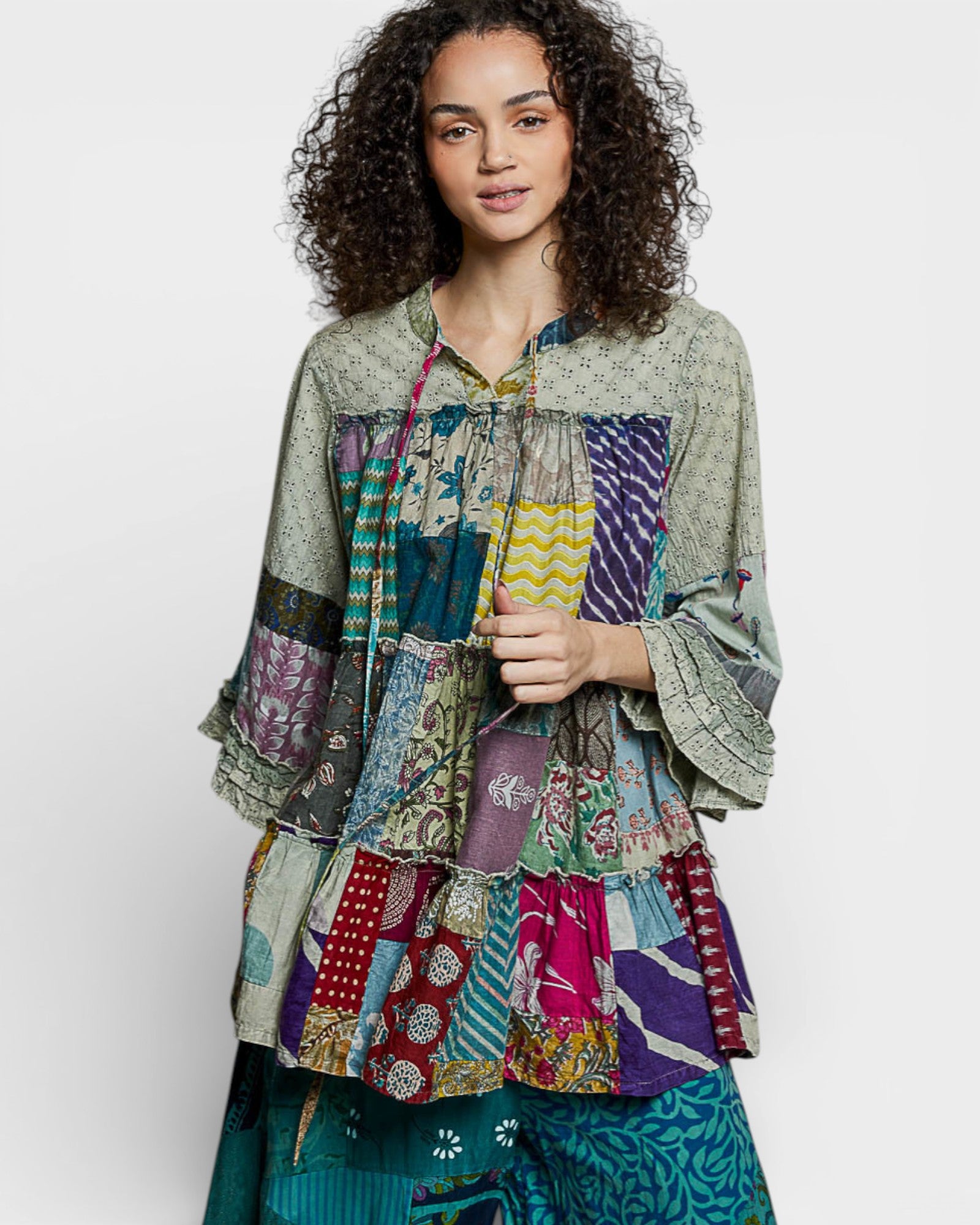 Woman wearing a colorful patchwork shirt on a white background
