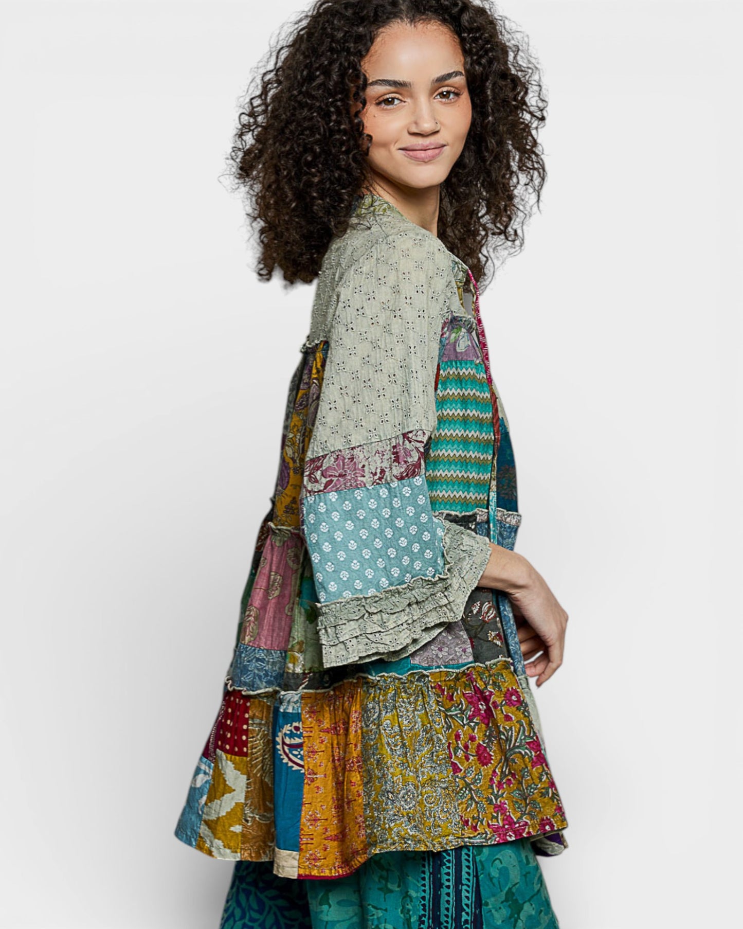 Woman wearing a colorful patchwork jacket on a white background