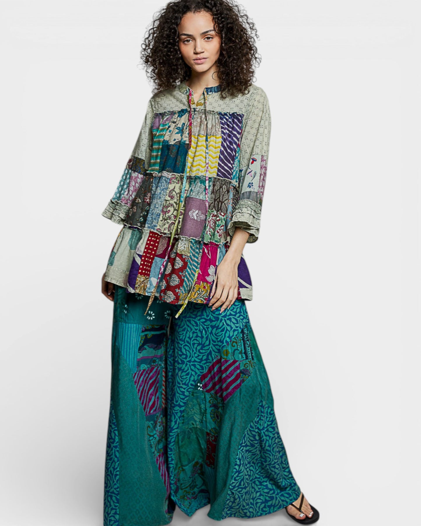 Woman wearing a colorful patchwork outfit on a white background