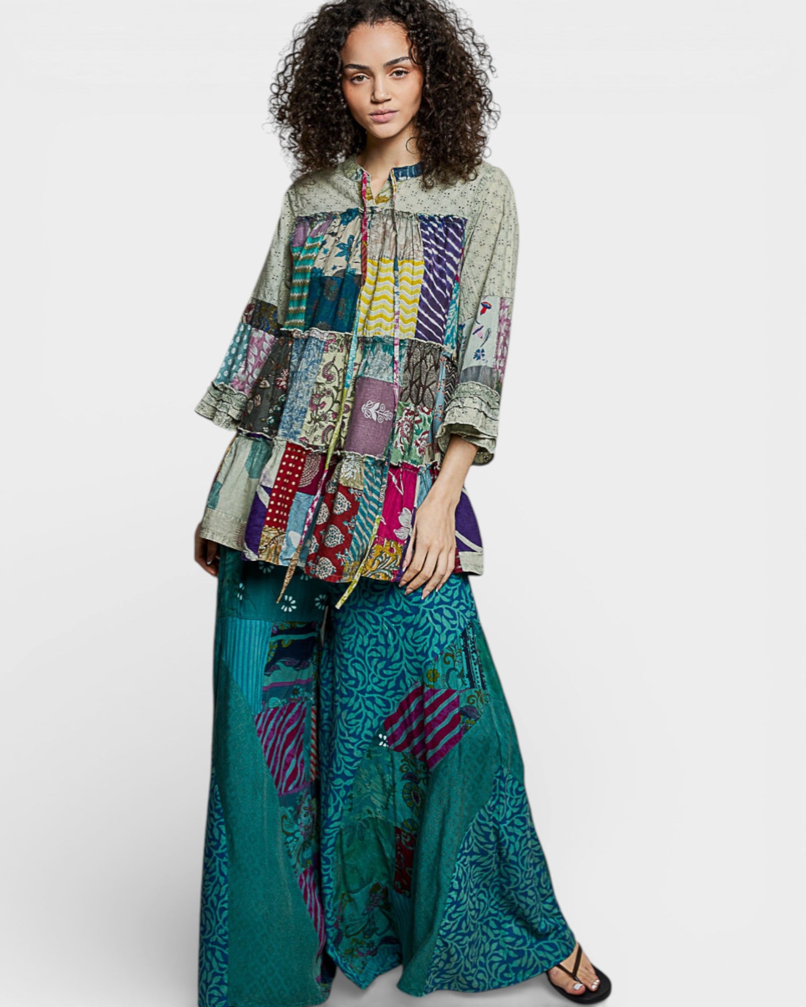 Woman wearing a colorful patchwork outfit on a white background