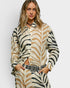 Woman wearing a zebra print outfit on a plain background