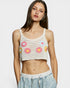 Woman wearing a crochet tank top with floral patterns on a plain background