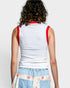 Person wearing a white sleeveless top with red straps on a plain background