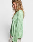 Woman wearing a green top on a white background