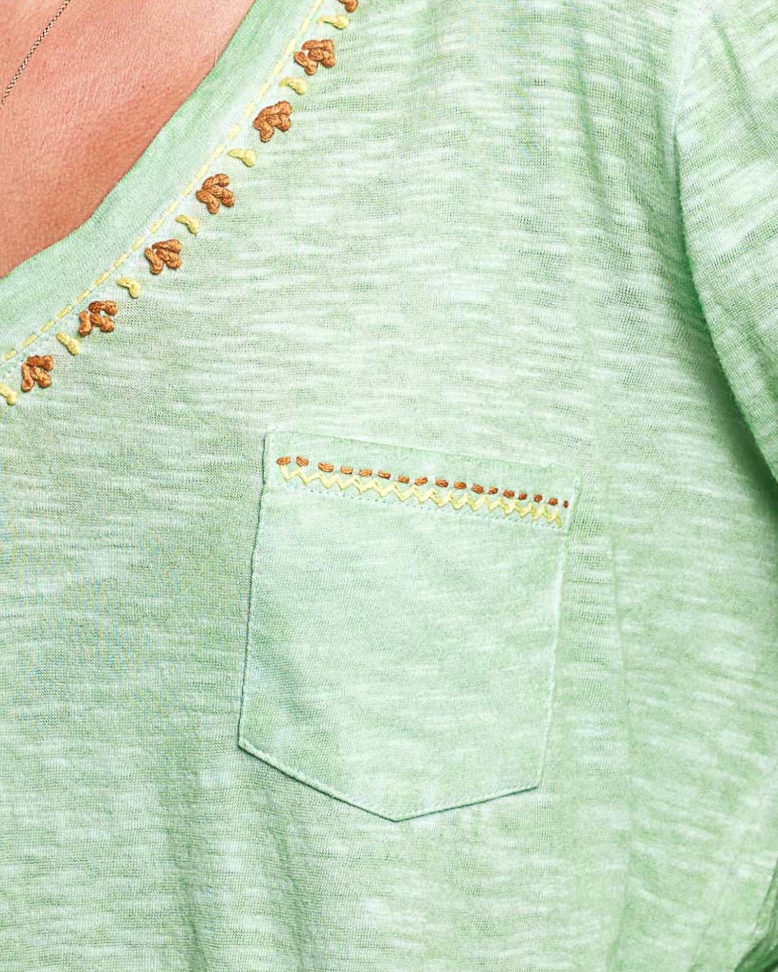 Close-up of a green garment with embroidered details
