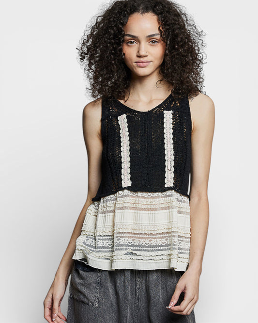 Woman wearing a black and white patterned sleeveless top on a white background