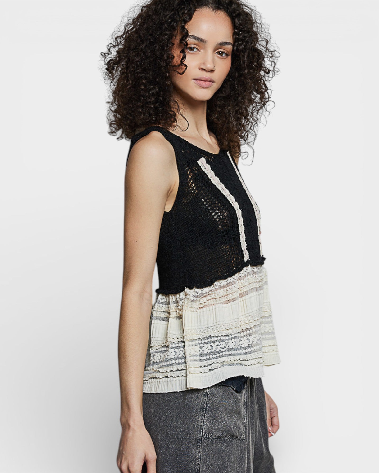 Woman wearing a black and white patterned sleeveless top on a white background