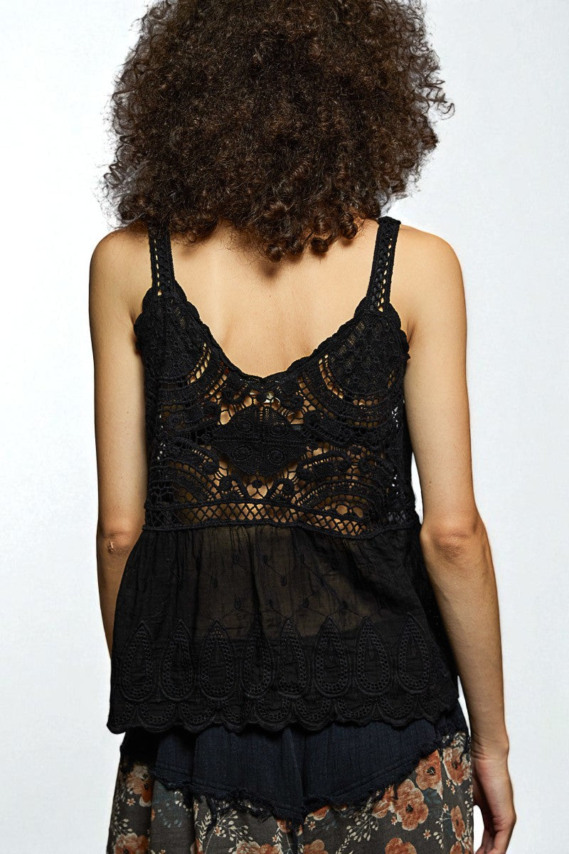 Black lace top worn by a person on a white background