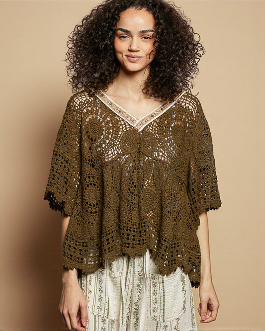 Woman wearing a brown crochet top against a beige background