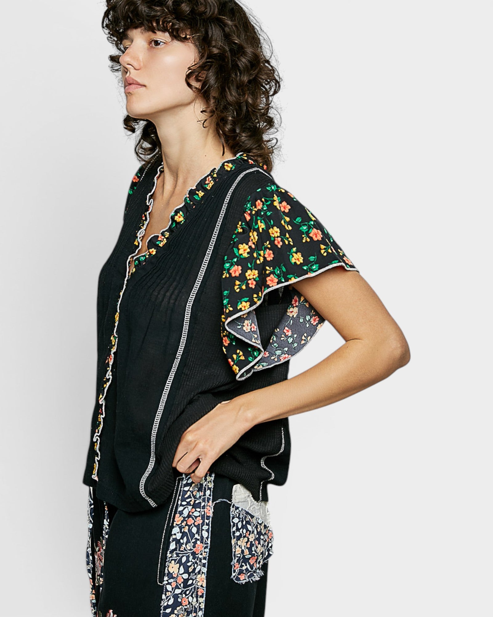 Woman wearing a black outfit with floral patterns on a white background