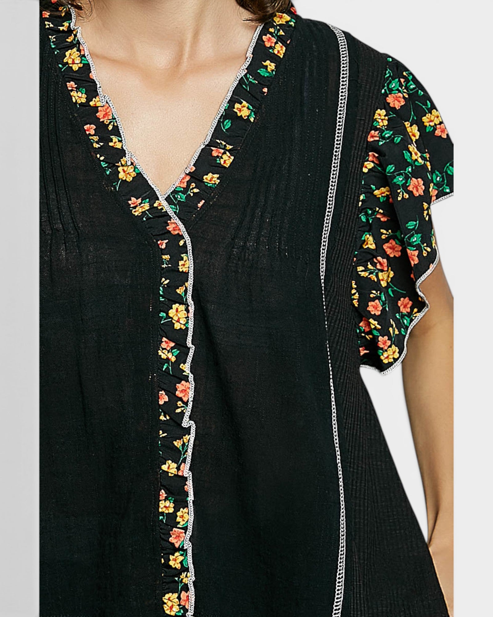 Black dress with floral embroidery on a plain background