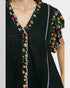 Black dress with floral embroidery on a plain background