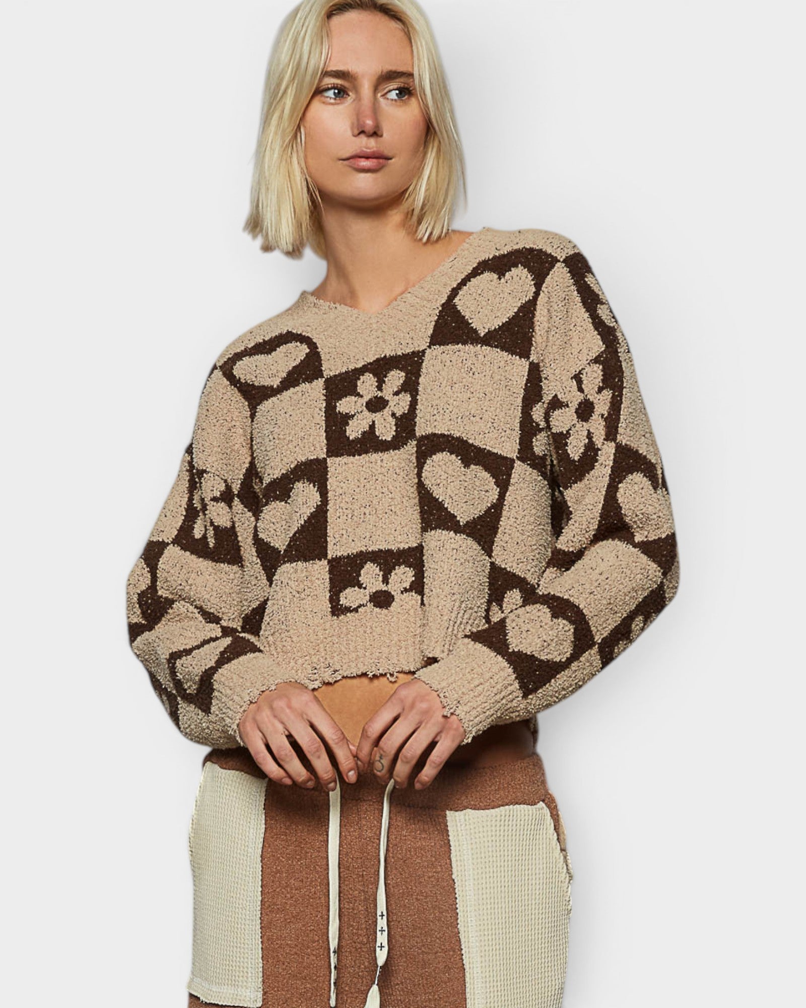 Person wearing a patterned sweater with a neutral background
