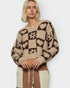 Person wearing a patterned sweater with a neutral background