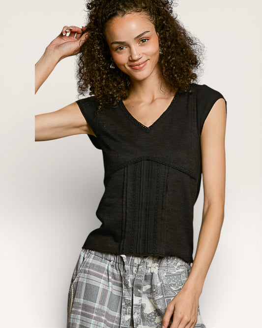 Woman wearing a black sleeveless top with plaid pants on a plain background