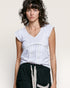 Woman wearing a light gray top with lace details on a plain background