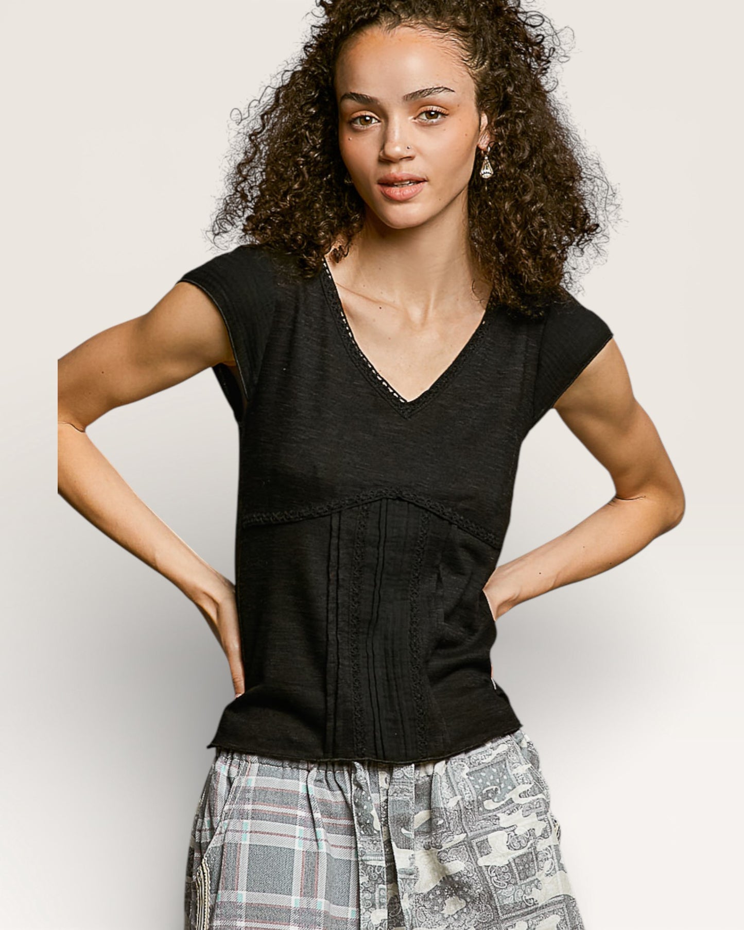 Woman wearing a black top with a plain background