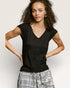 Woman wearing a black top with a plain background