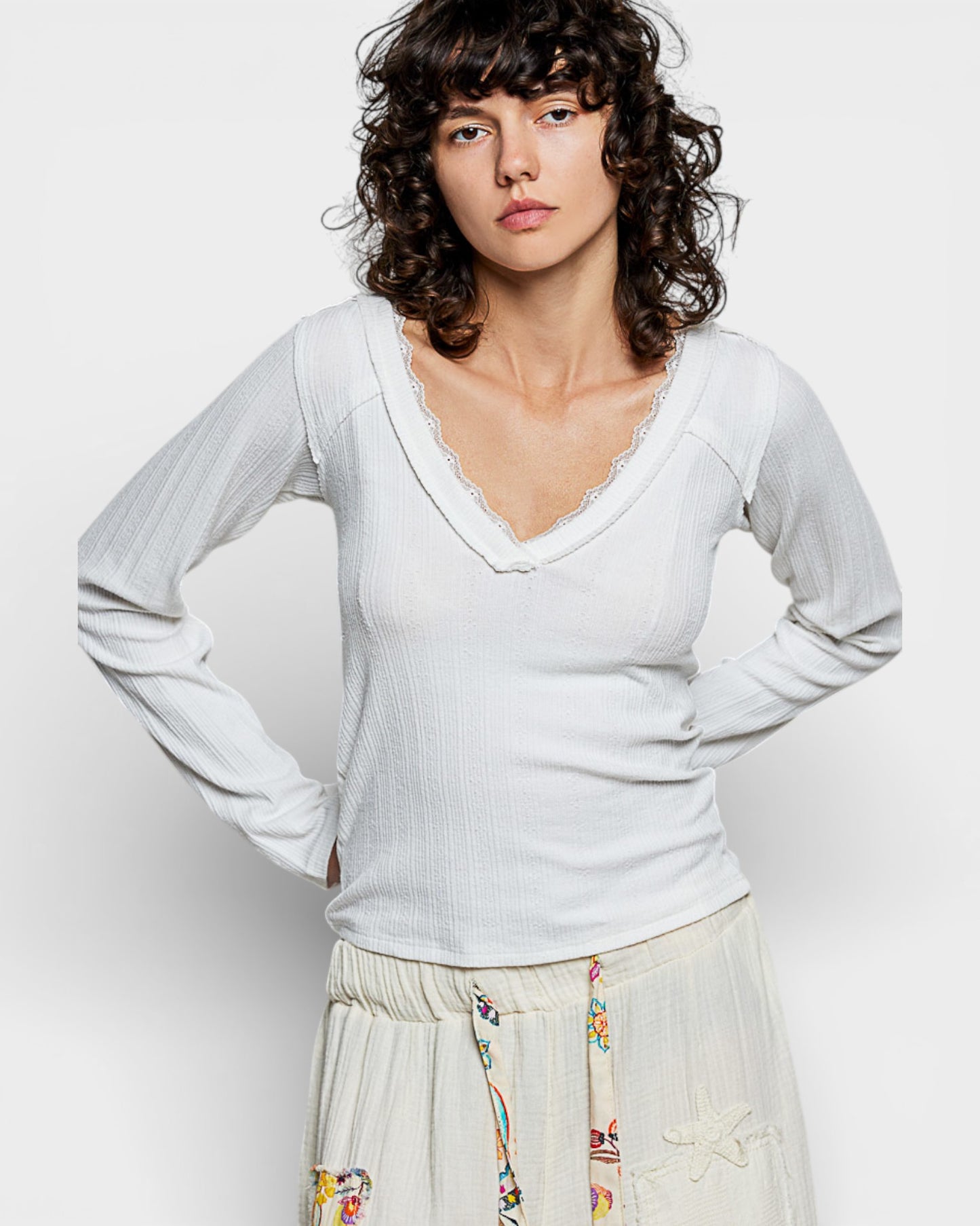 Woman wearing a light gray long-sleeve top against a plain background