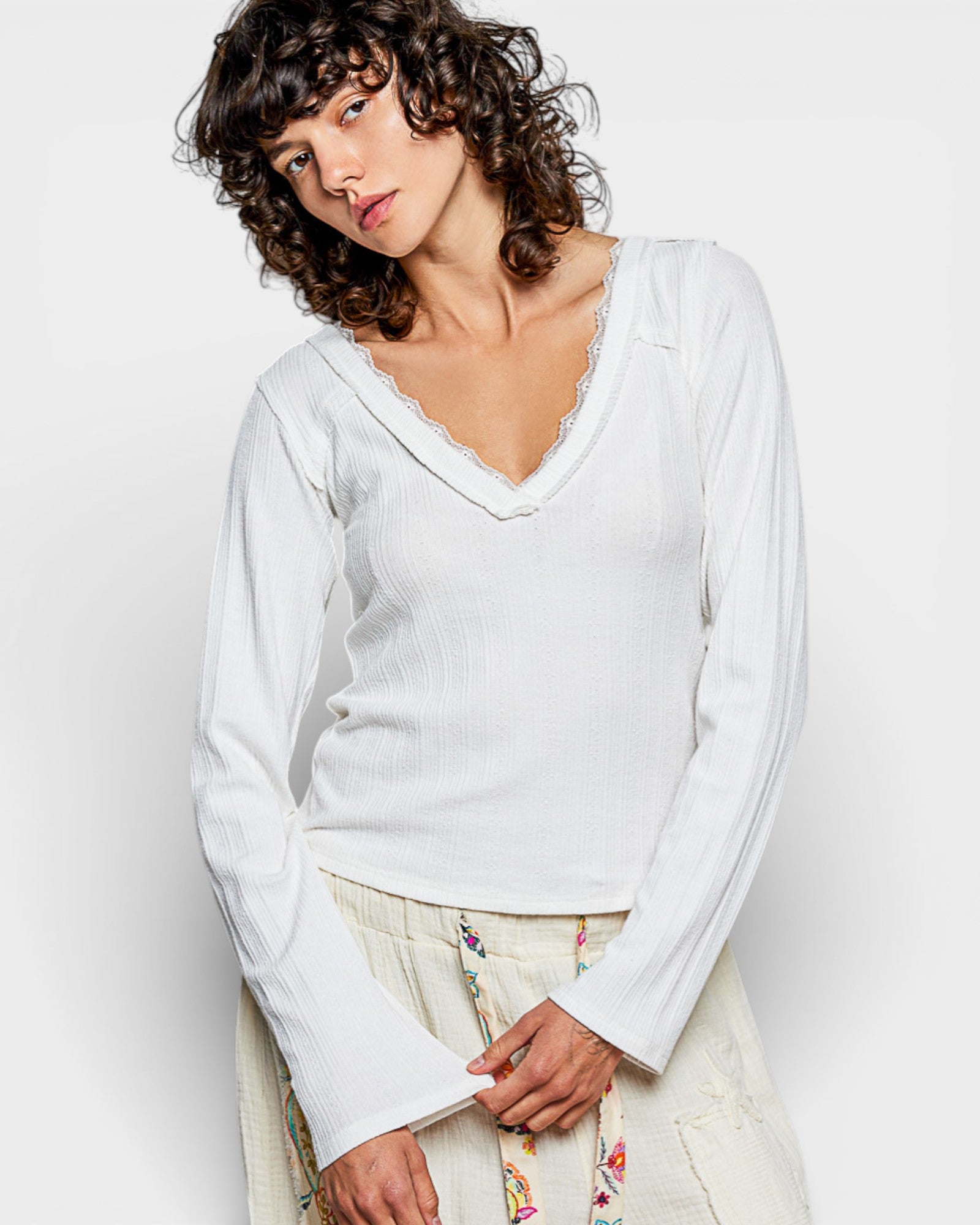 Woman wearing a white sweater against a plain background