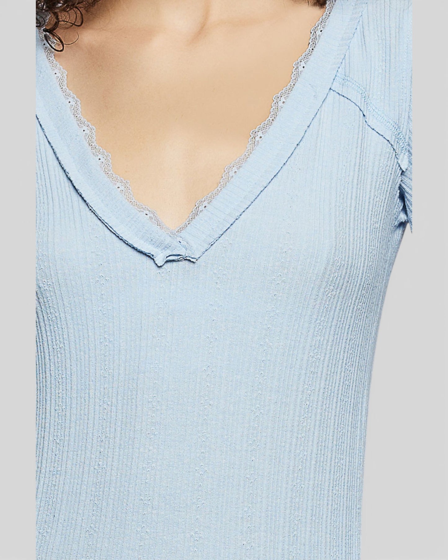 Light blue ribbed top with lace trim on a plain background
