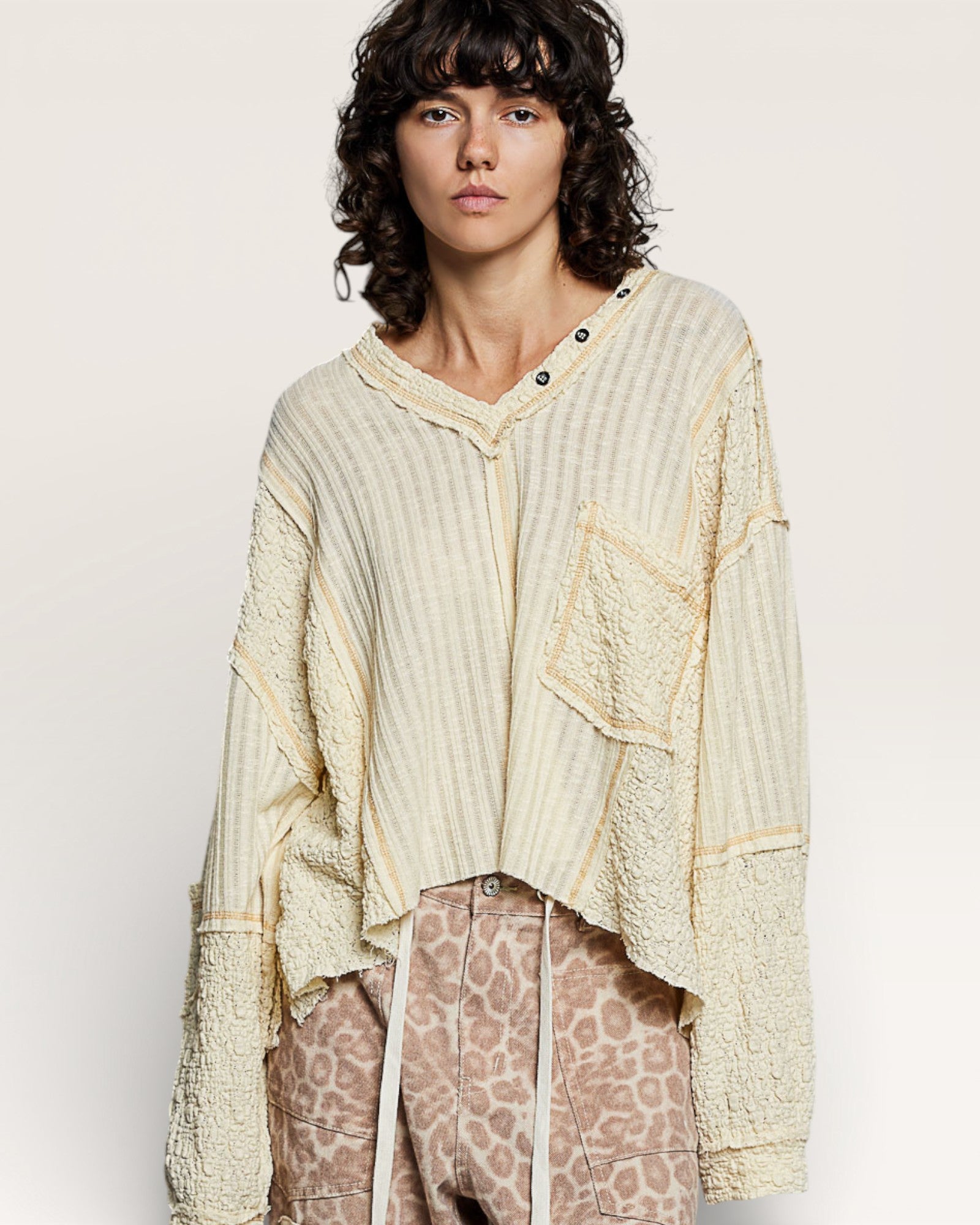Person wearing a light-colored textured shirt with a plain background