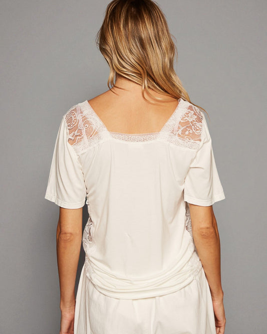 White lace dress worn by a person on a gray background